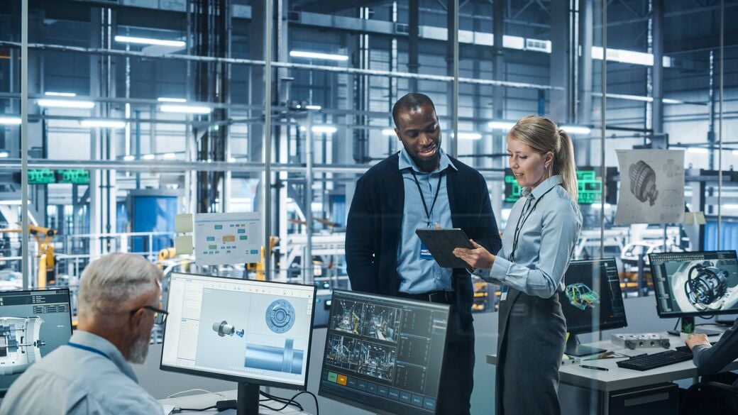 Engineers talking and using a tablet at factory